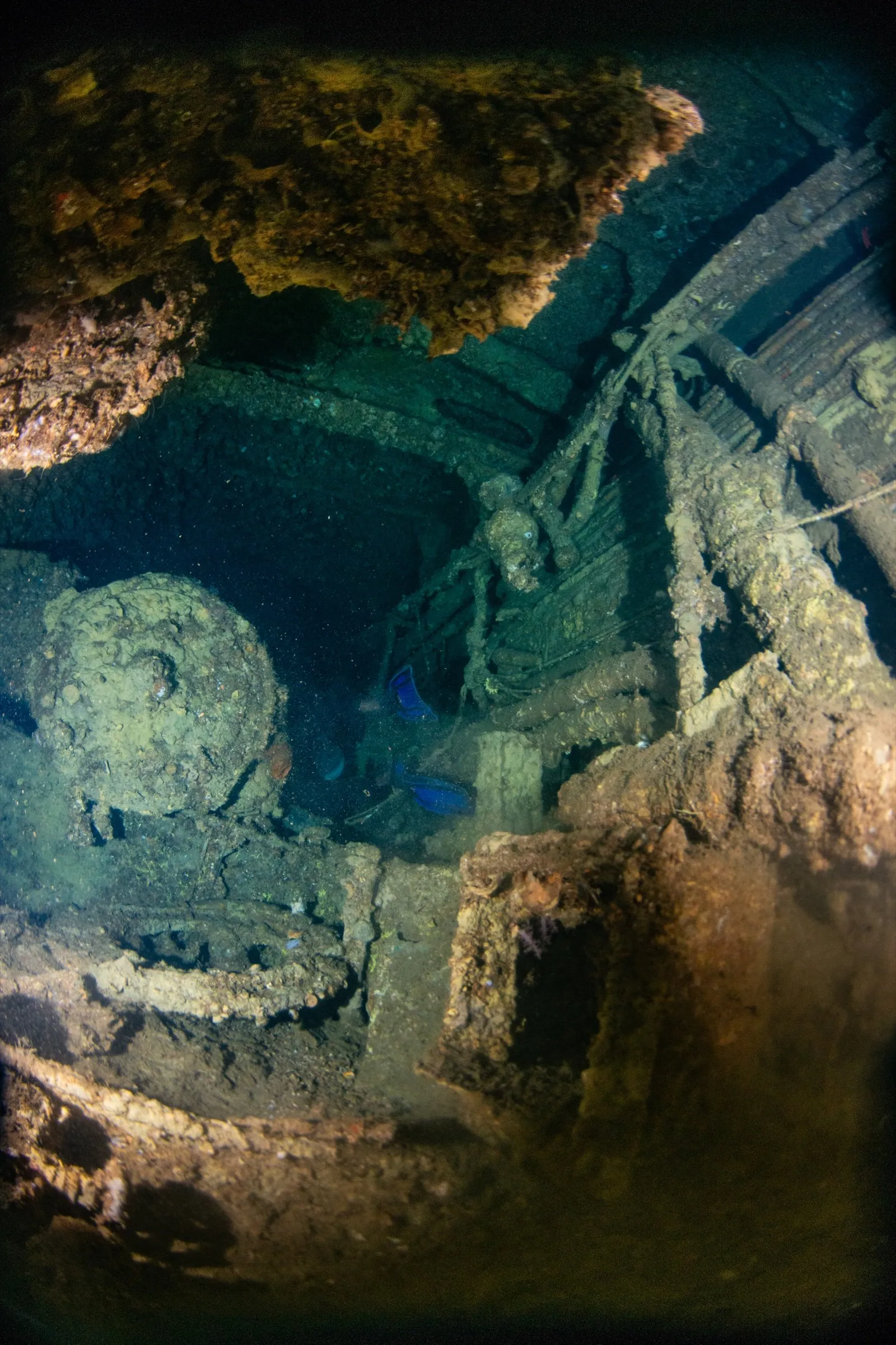 Corroded, encrusted machinery inside a dark wreck interior